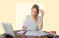 Woman appearing stressed when looking at financial documents