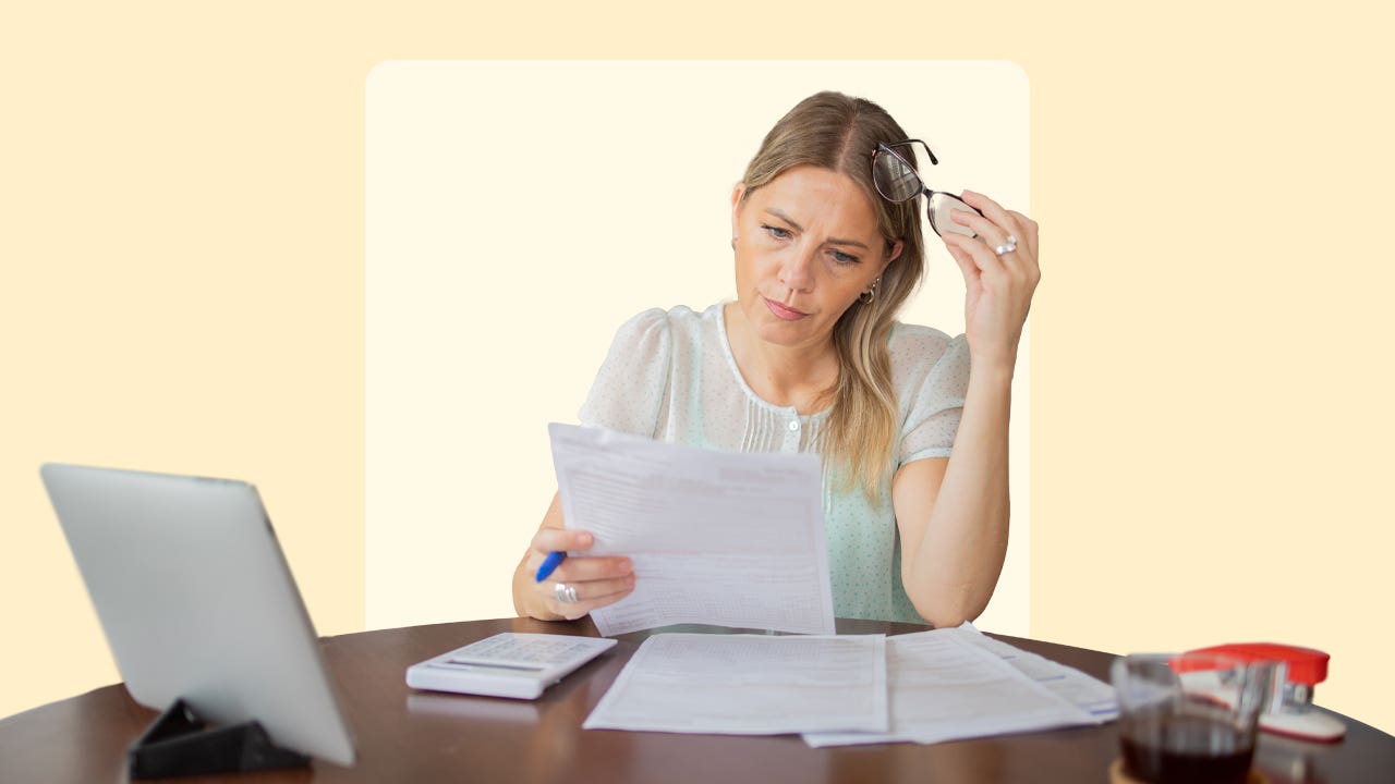 Woman appearing stressed when looking at financial documents