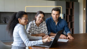 Three people reviewing a laptop together