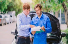A car mechanic consulting with a client