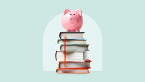 A pink piggy bank sits on top of a stack of books on an aqua background.