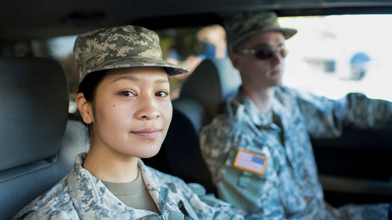 asian woman and white man in military uniform inside a car