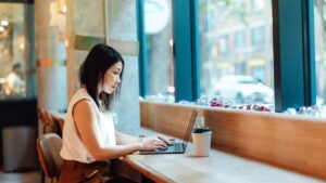 Woman on laptop in cafe.