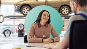 A woman in a car repair shop