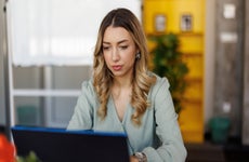 business woman sitting at the desk and working on laptop in modern office