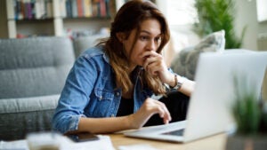 Worried young woman working at home