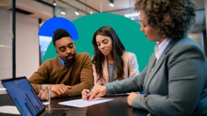 A financial advisor explaining something to a young couple, clients