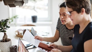 couple discussing over financial bills while using laptop at table