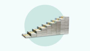 A stack of cash arranged to resemble a staircase set against a solid green background.