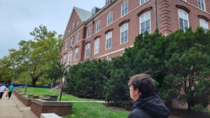 Young man looking out over a college campus