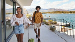 Young couple walking on deck by sea in summer