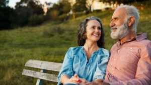 Man and woman on bench, smiling