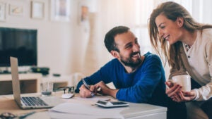 Couple sitting in their living room and checking their finances