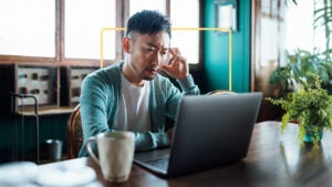 Man at laptop, deep in thought