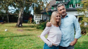 Smiling man with arm around woman at backyard