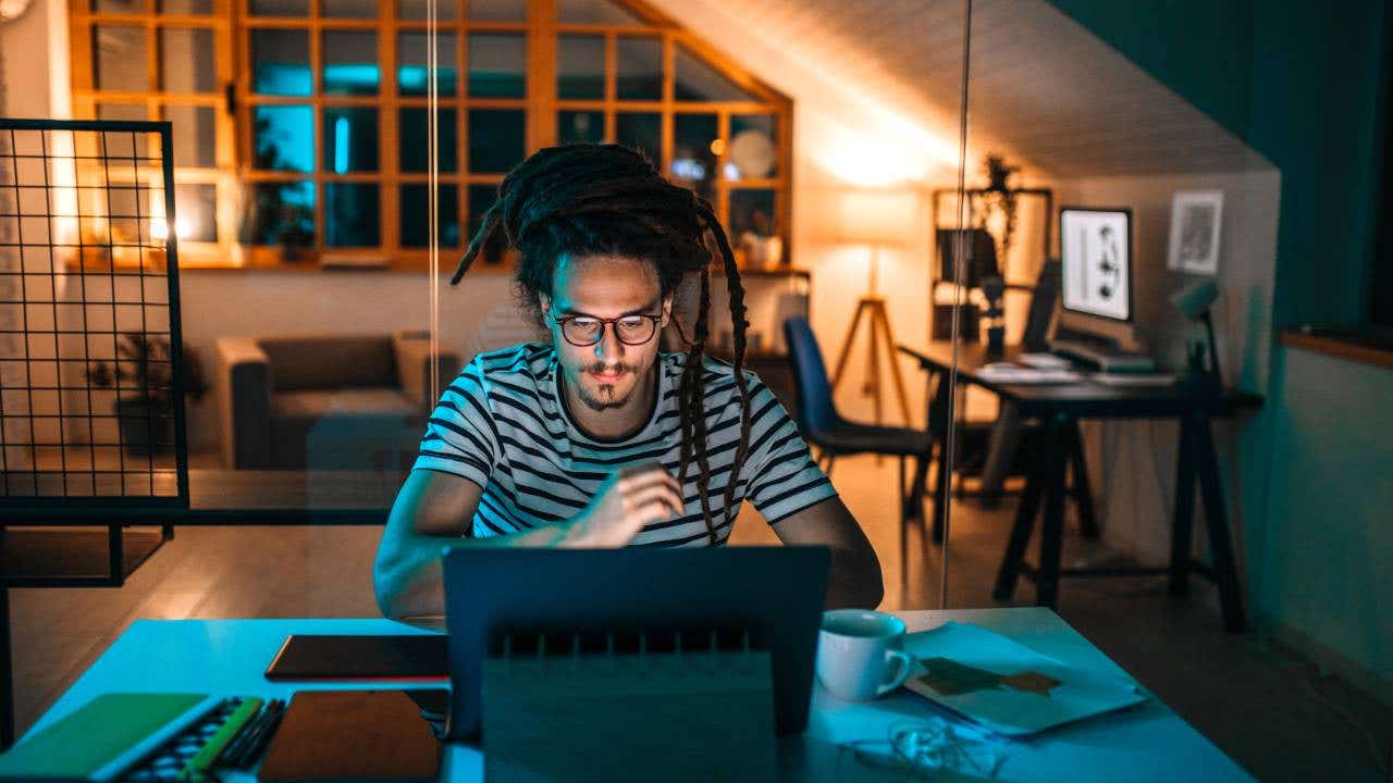 Young man late night working in home office