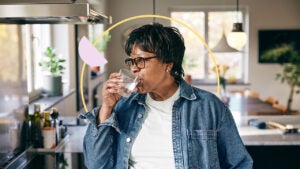 Woman casually drinking in her kitchen