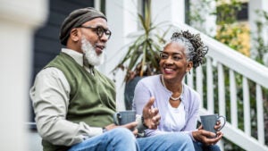 An older couple enjoying a hot beverage on their porch