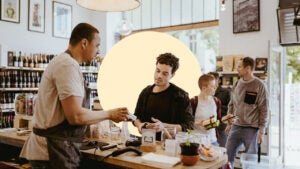 Man completes purchase at a wine store using a credit card machine.