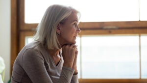 Upset mature woman look in distance feeling sad mourning