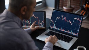 Man Checking His Stock Market Exchange Investment Using His Laptop Computer