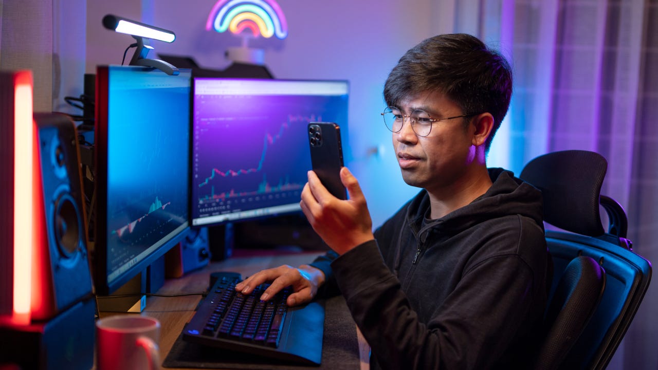 trading and currency trading app on his smartphone