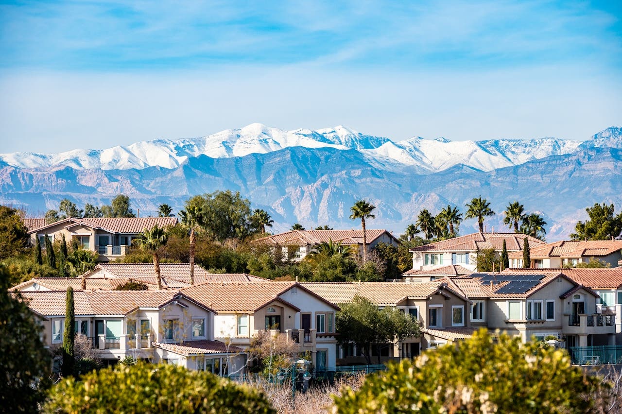 aerial view of suburban las vegas homes with palm trees and mountains
