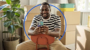 Person sitting in chair looking at phone and smiling