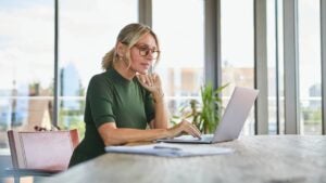 woman using laptop on table at home