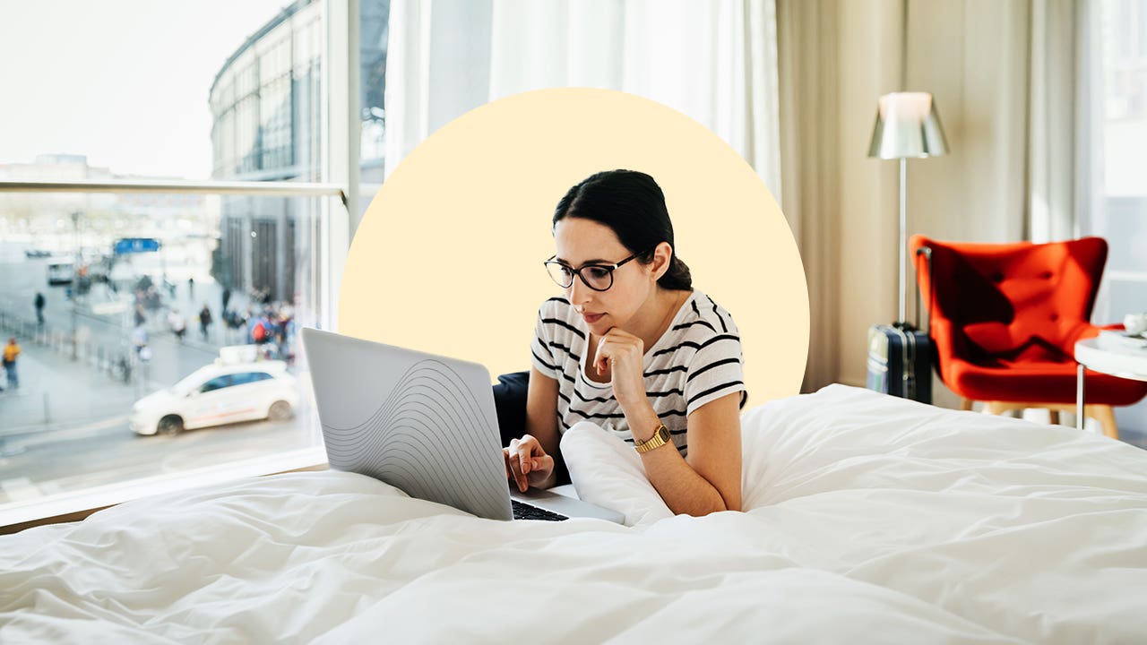 design image depicting a woman laying on her bed on her laptop