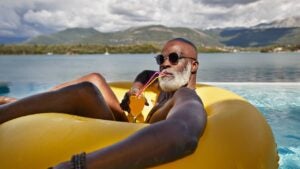 Man drinking juice in inflatable ring