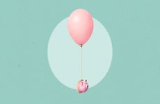 A piggy bank floating away attached to a large balloon