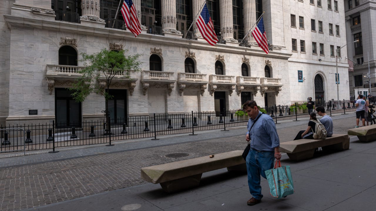 People walk by the outside of the New York Stock Exchange