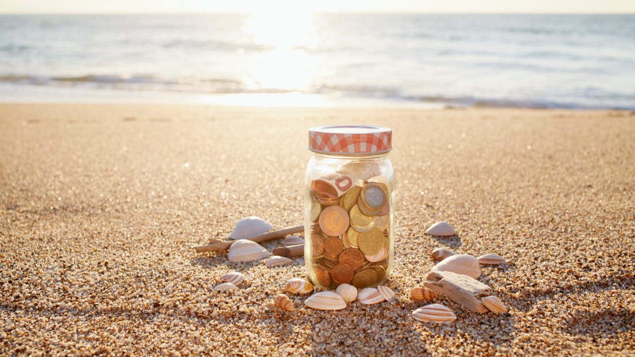 coins in jar at the beach during sunset