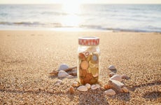 coins in jar at the beach during sunset