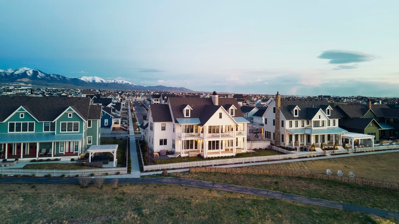 Aerial view of a community of luxury homes, taken at sunrise.