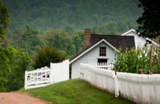 A farmhouse with a white picket fence