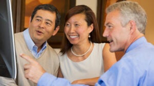 Couple looking at computer with their financial advisor