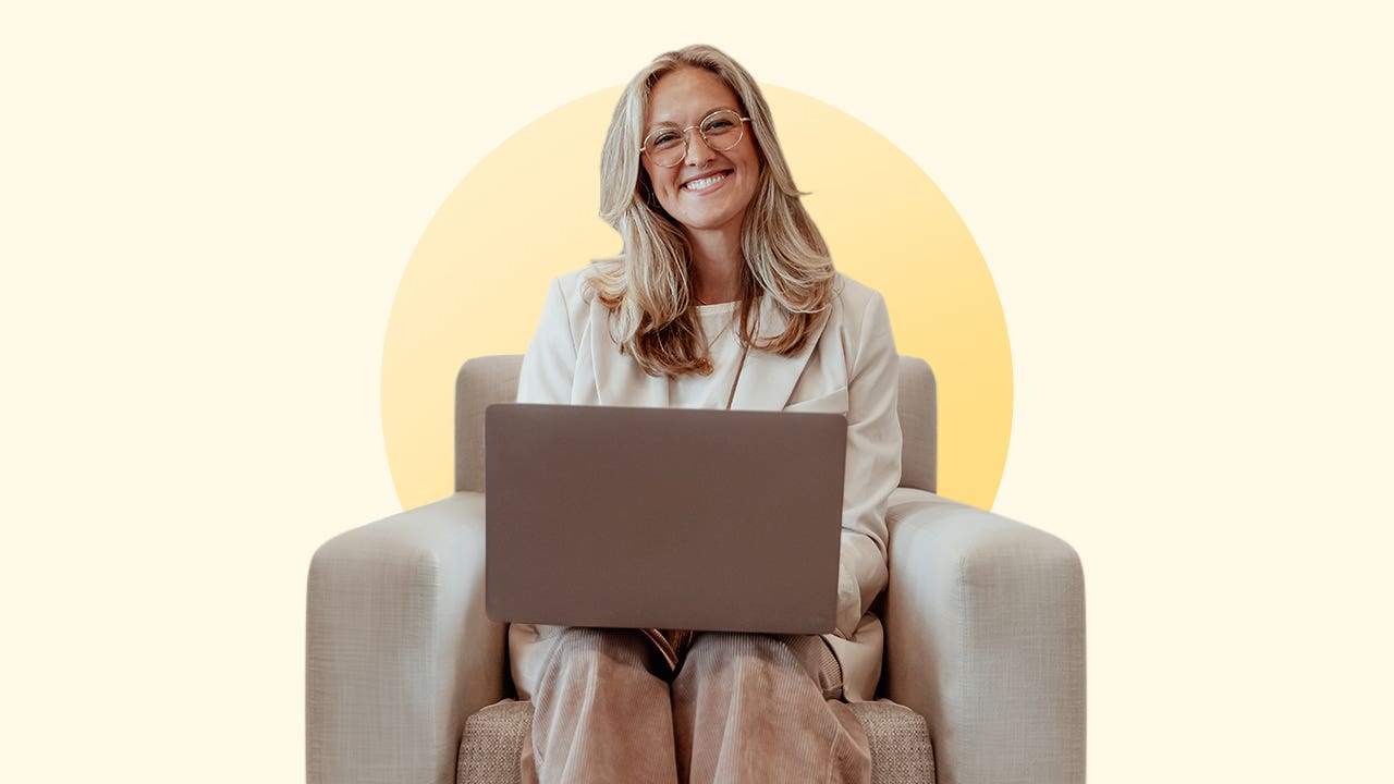 design image of katie kelton on a couch with her laptop on her lap