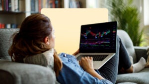 Woman casually looking at financial charts on the couch