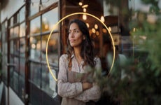 design image of a women standing with her arms crossed in front of a store