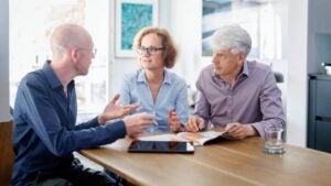 A couple sits at a table while speaking with a financial advisor.