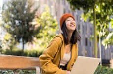 Asian female using laptop outside university in campus