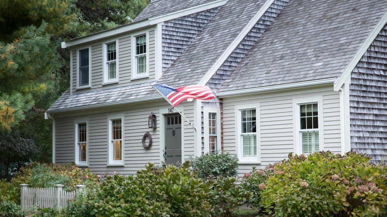 gray clapboard house with american flag, cape cod massachusetts