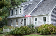 gray clapboard house with american flag, cape cod massachusetts