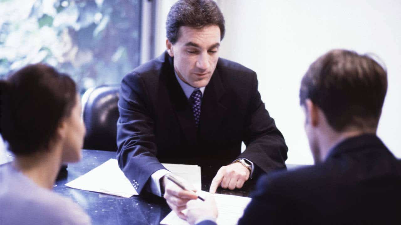 Financial advisor explaining a contract to a couple.