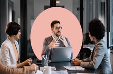 Three people in an office setting having a discussion.