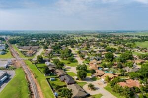 aerial view of an oklahoma suburb with houses, trees, green grass