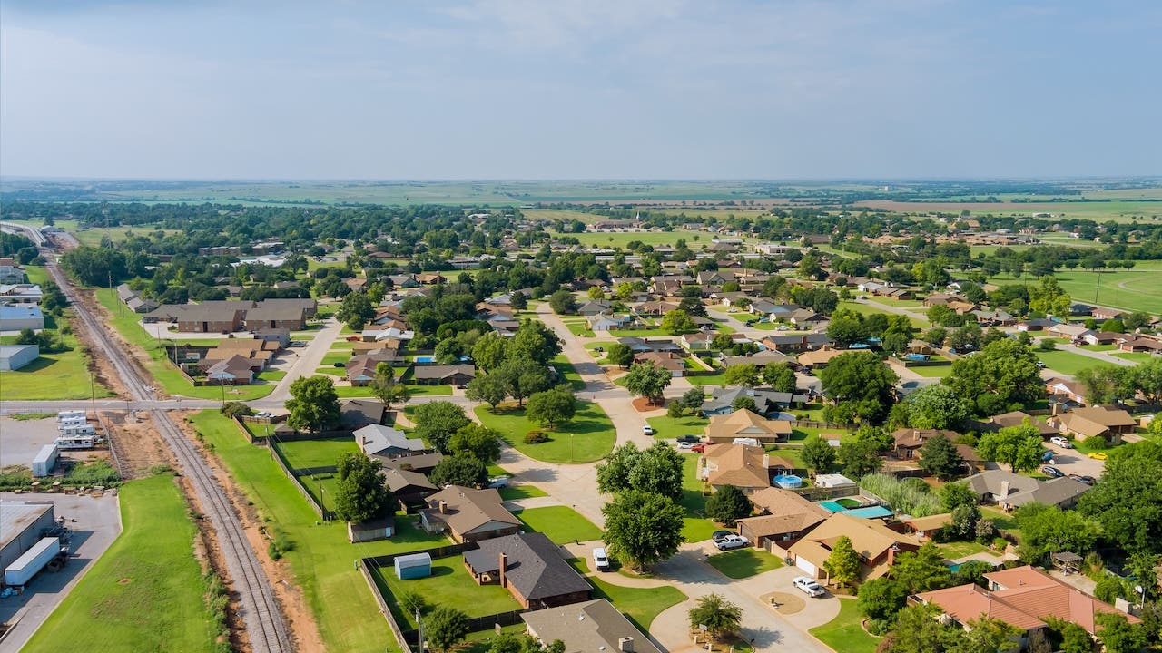 aerial view of an oklahoma suburb with houses, trees, green grass