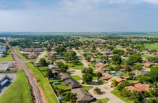 aerial view of an oklahoma suburb with houses, trees, green grass